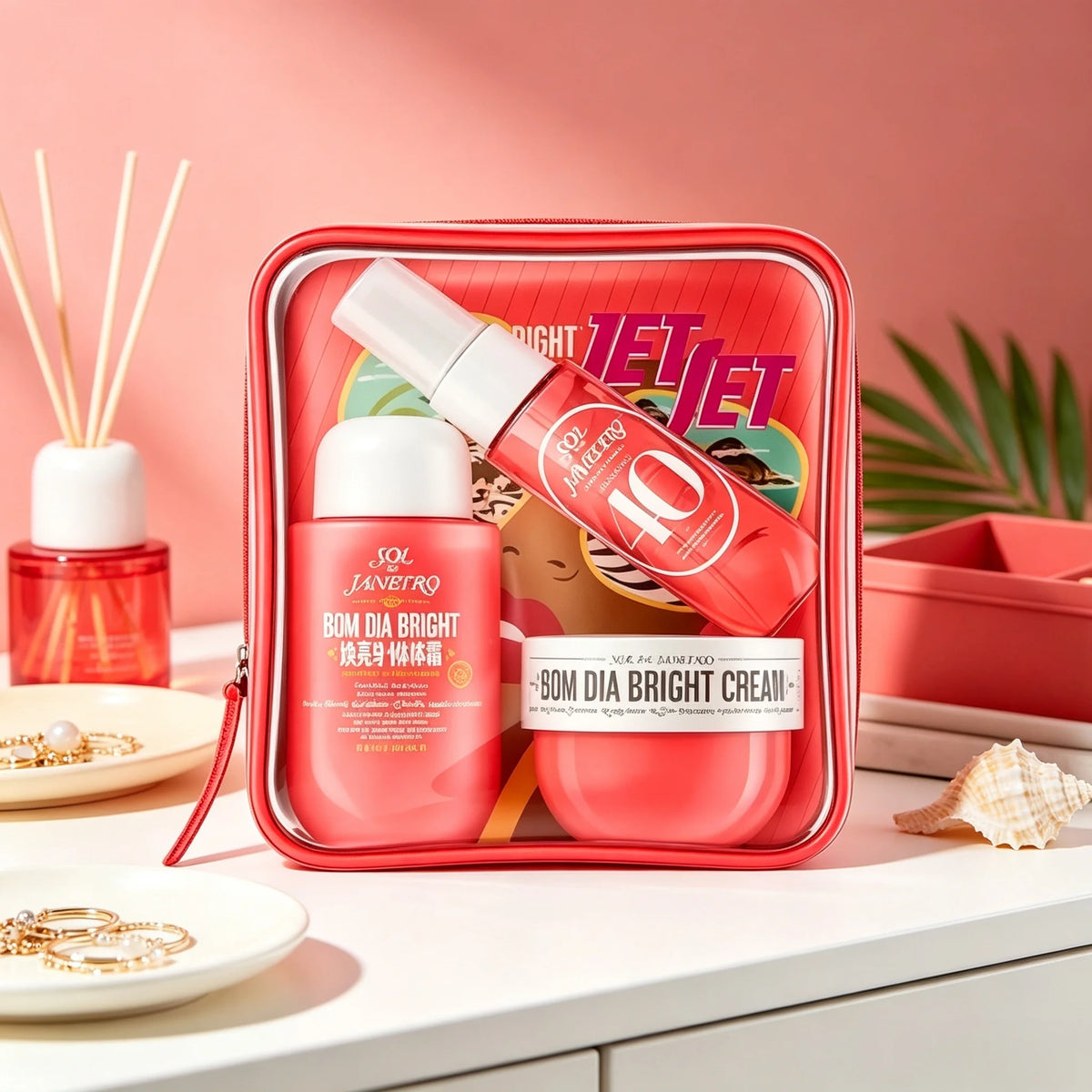 Sol de Janeiro Delicia Drench Body Care Travel Gift Set: A purple, transparent zippered cosmetic bag containing nourishing shower oil, No. 59 fragrance spray, and a mini skincare set with a long-lasting, warm vanilla-sandalwo