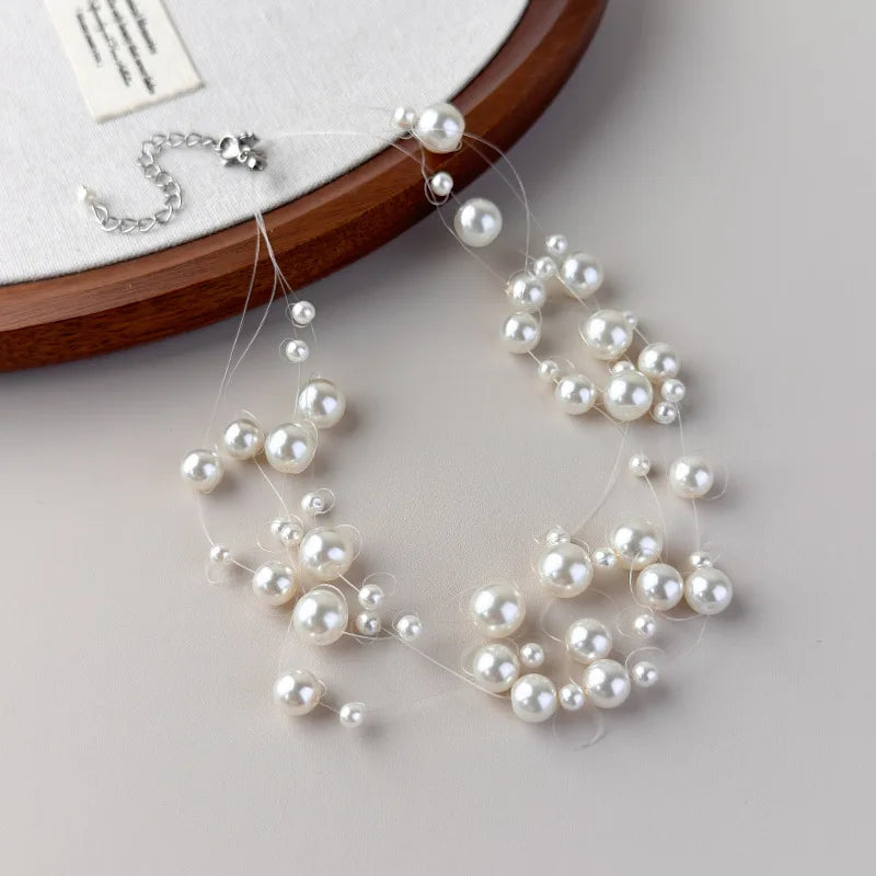 Stylish, minimalist layered necklace with pearls of varying sizes, paired with a star-studded necklace