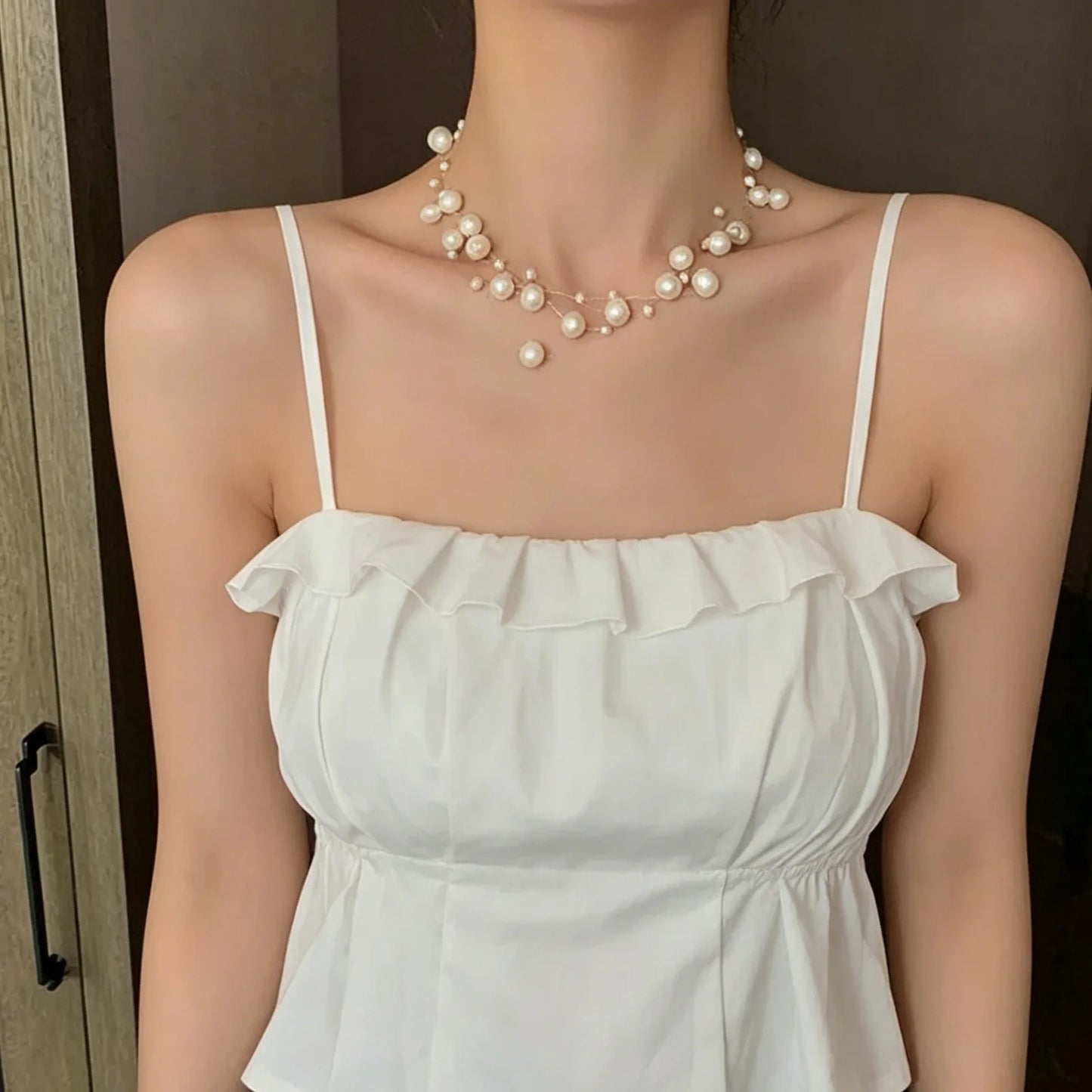 Stylish, minimalist layered necklace with pearls of varying sizes, paired with a star-studded necklace