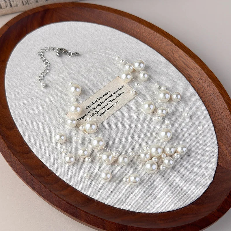Stylish, minimalist layered necklace with pearls of varying sizes, paired with a star-studded necklace