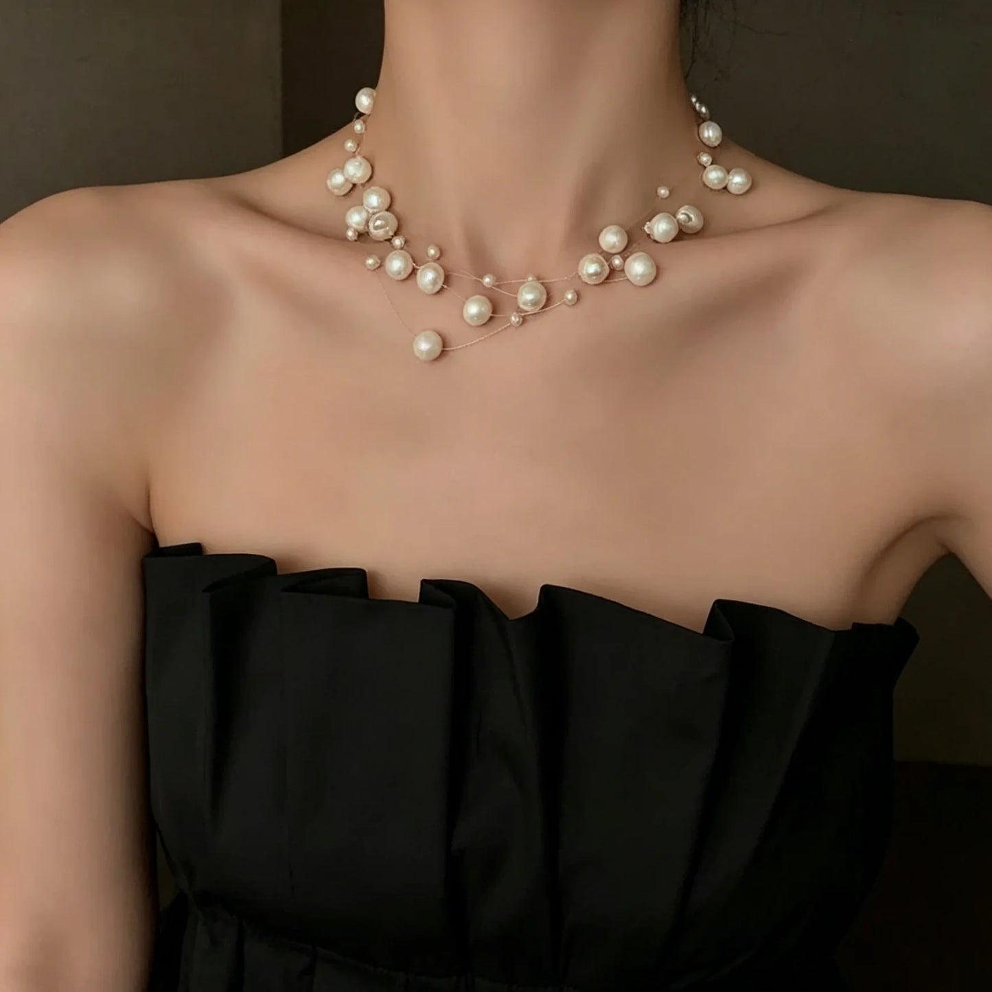 Stylish, minimalist layered necklace with pearls of varying sizes, paired with a star-studded necklace